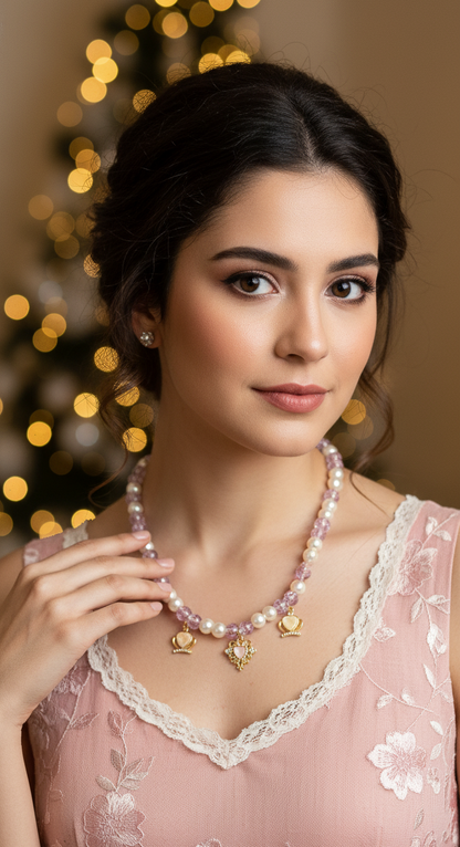 Woman wearing a pink dress and necklace with a blurred Christmas tree in the background
