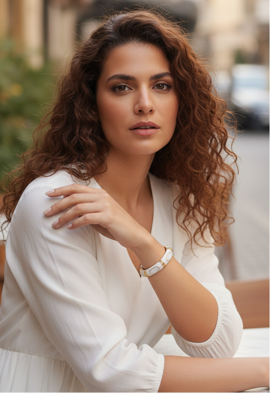 Woman in a white outfit sitting outdoors with blurred background
