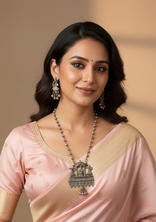 Woman wearing a pink saree with a beige blouse against a neutral background