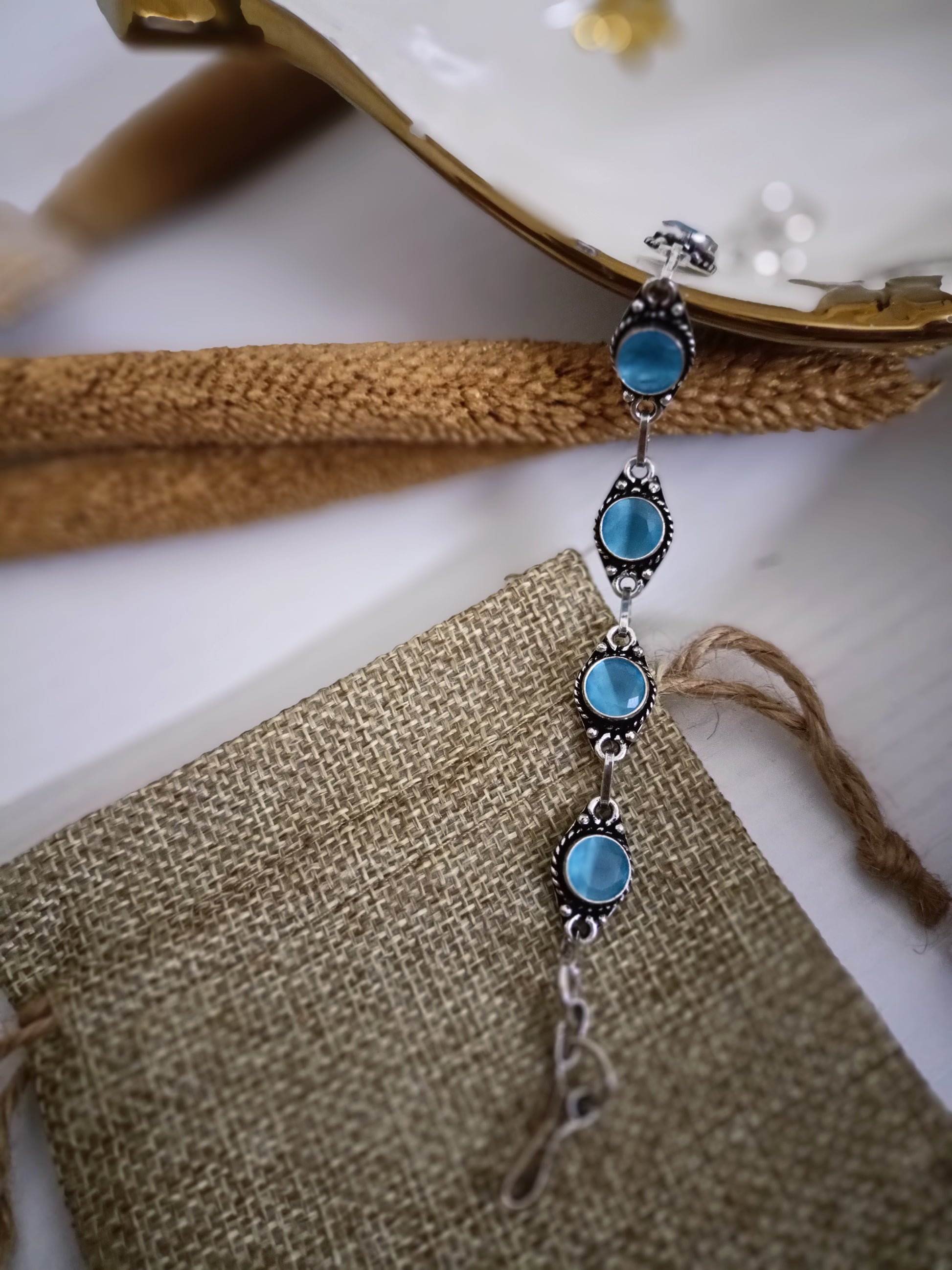 Jewelry with blue stones and silver accents on a textured surface