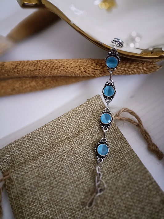 Jewelry with blue stones and silver accents on a textured surface