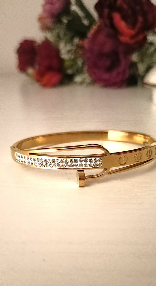 Gold bracelet with crystals on a light background