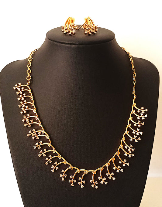 Gold necklace and earrings on a black mannequin bust