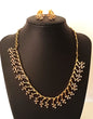 Gold necklace and earrings on a black mannequin bust